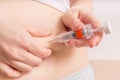 Woman is injecting hormones to belly with syringe. Royalty Free Stock Photo