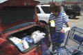 Woman placing groceries in the trunk of her car in Bellville, Michigan