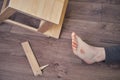 Woman injured foot on leg after falling from wooden stepladder. The problem with labor protection at diy work at home