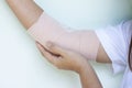 Woman injured her elbow first aid is wrapped with elastic bandage to prevent musculoskeletal movements.