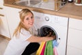 Woman Inserting Clothes In Washing Machine Royalty Free Stock Photo