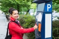 Woman Inserting Coin In Parking Meter