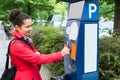 Woman Inserting Coin In Parking Meter