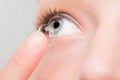 Woman inserting a contact lens in eye. Royalty Free Stock Photo