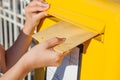 Woman inserting envelope in mailbox Royalty Free Stock Photo