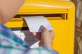 Woman inserting envelope in mailbox Royalty Free Stock Photo