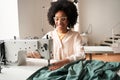 Woman inserting the fabric under the needle at the sewing machine