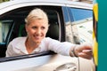 Woman is inserting parking ticket into barrier