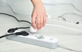 Woman inserting power plug into extension cord on floor, closeup