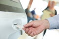 Woman inserting ticket into machine to pay for parking Royalty Free Stock Photo