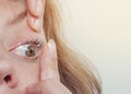 Woman inserts a contact lens into the eye. Close-up, domestic scene. Optics, Vision, Optical Instruments Royalty Free Stock Photo