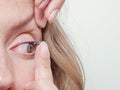 Woman inserts a contact lens into the eye Royalty Free Stock Photo