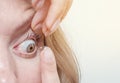 Woman inserts a contact lens into the eye