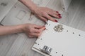 A woman inserts wooden pins into the sidewall of the furniture w Royalty Free Stock Photo