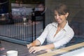 Woman inside coffee shop working on laptop