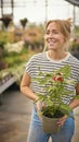 Woman Inside Greenhouse In Garden Centre Choosing And Buying Red Echinacea Plant Royalty Free Stock Photo