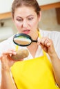 Woman inspecting potato with magnifying glass. Royalty Free Stock Photo