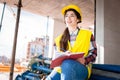 Girl in a construction helmet and vest writes in a notebook at a construction site Royalty Free Stock Photo