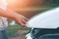 Woman inspects the damage of a damaged car on the road Royalty Free Stock Photo