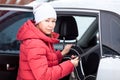 Woman installing child safety seat on back of car, woman in winter clothes