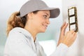 Woman installing electrical switches checking fastening screws