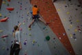 Woman instructing athlete in climbing wall at health club