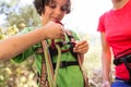 A woman instructs how to use a carabiner for belaying