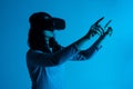 A woman interacts with a virtual interface, reaching outward with both hands while wearing a VR headset Royalty Free Stock Photo