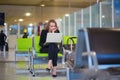 Woman in international airport terminal, working on her laptop Royalty Free Stock Photo