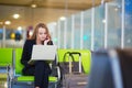 Woman in international airport terminal, working on her laptop Royalty Free Stock Photo