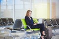 Woman in international airport terminal, working on her laptop Royalty Free Stock Photo