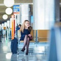 Woman in international airport waiting for her flight Royalty Free Stock Photo