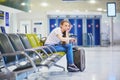 Woman in international airport waiting for her flight Royalty Free Stock Photo