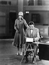 Woman interrupting man at typewriter Royalty Free Stock Photo