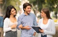 Woman Interviewing Couple Conducting Opinion Poll Walking In City Outdoor.