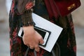 Woman with iPhone with cover with studs and black and red floral dress before Luisa Beccaria fashion show,