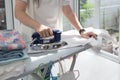 Woman ironing clothes using iron on ironing board Royalty Free Stock Photo