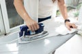 Woman ironing clothes using iron on ironing board Royalty Free Stock Photo