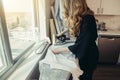 Woman ironing with professional iron with water steam at home