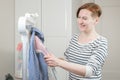 Woman ironing a striped business shirt with a handheld garment steamer Royalty Free Stock Photo