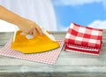 Woman ironing tablecloths on rustic grey table with a blue white