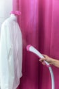 Woman ironing white shirt with garment pink steamer Royalty Free Stock Photo