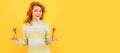 Woman isolated face portrait, banner with copy space. glad redhead girl with red heart sticks on yellow background. Royalty Free Stock Photo