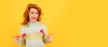 Woman isolated face portrait, banner with copy space. happy cheerful redhead girl with red heart sticks on yellow Royalty Free Stock Photo