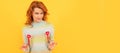 Woman isolated face portrait, banner with copy space. positive flirty redhead girl with red heart sticks on yellow Royalty Free Stock Photo