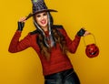 Woman isolated on yellow background holding jack-o-lantern Royalty Free Stock Photo