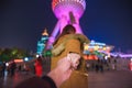 Woman in jacket clothes leading man to oriental pearl tower in shanghai