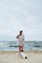 Woman in jacket looking at dog near sea Royalty Free Stock Photo