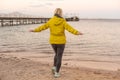 Woman in jacket near sea at sunrise cold morning Royalty Free Stock Photo