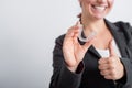 A woman in a jacket shows her thumbs up and demonstrates mouth guards to align the bite. The girl approves of the